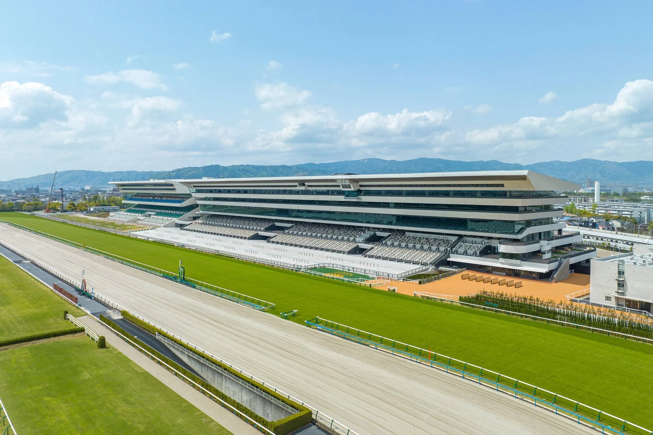 Charakterbild - This image does not contain any characters or people. It is a wide aerial view of a modern horse rac